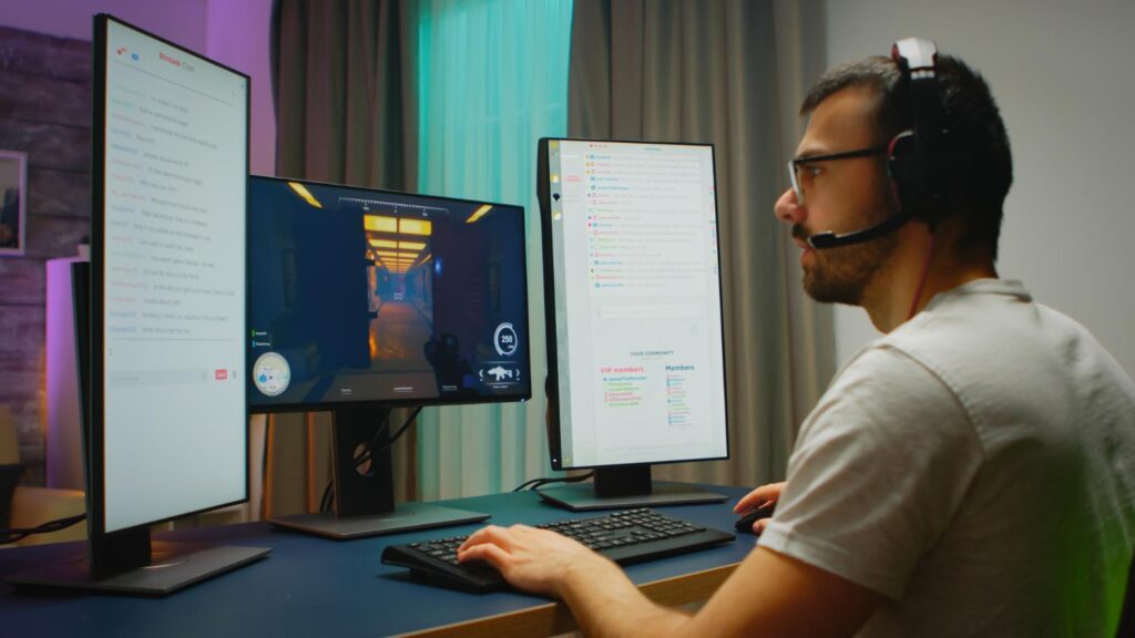 A software engineer coding on a desktop computer with multiple monitors