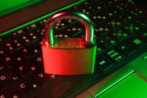 How HR Teams Can Reduce the Risk of Employee Email Accounts Being Spoofed A neon-lit padlock glowing red and green sits on a gaming keyboard illuminated by RGB lighting.