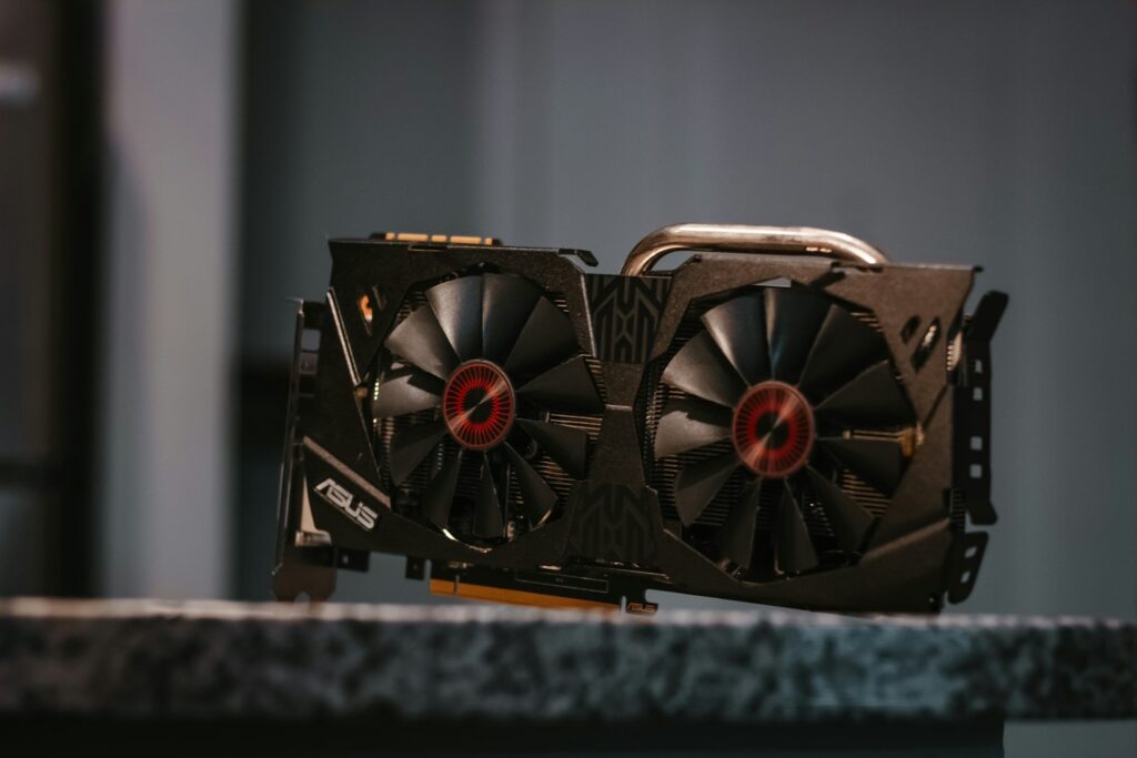 High-end graphics card with dual cooling fans featuring red LED centers, mounted on a textured surface