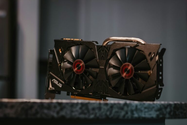 High-end graphics card with dual cooling fans featuring red LED centers, mounted on a textured surface